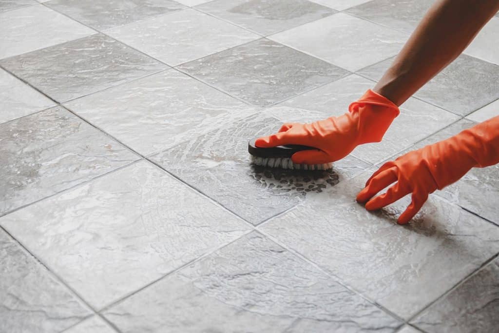 Cleaning tile floor with brush